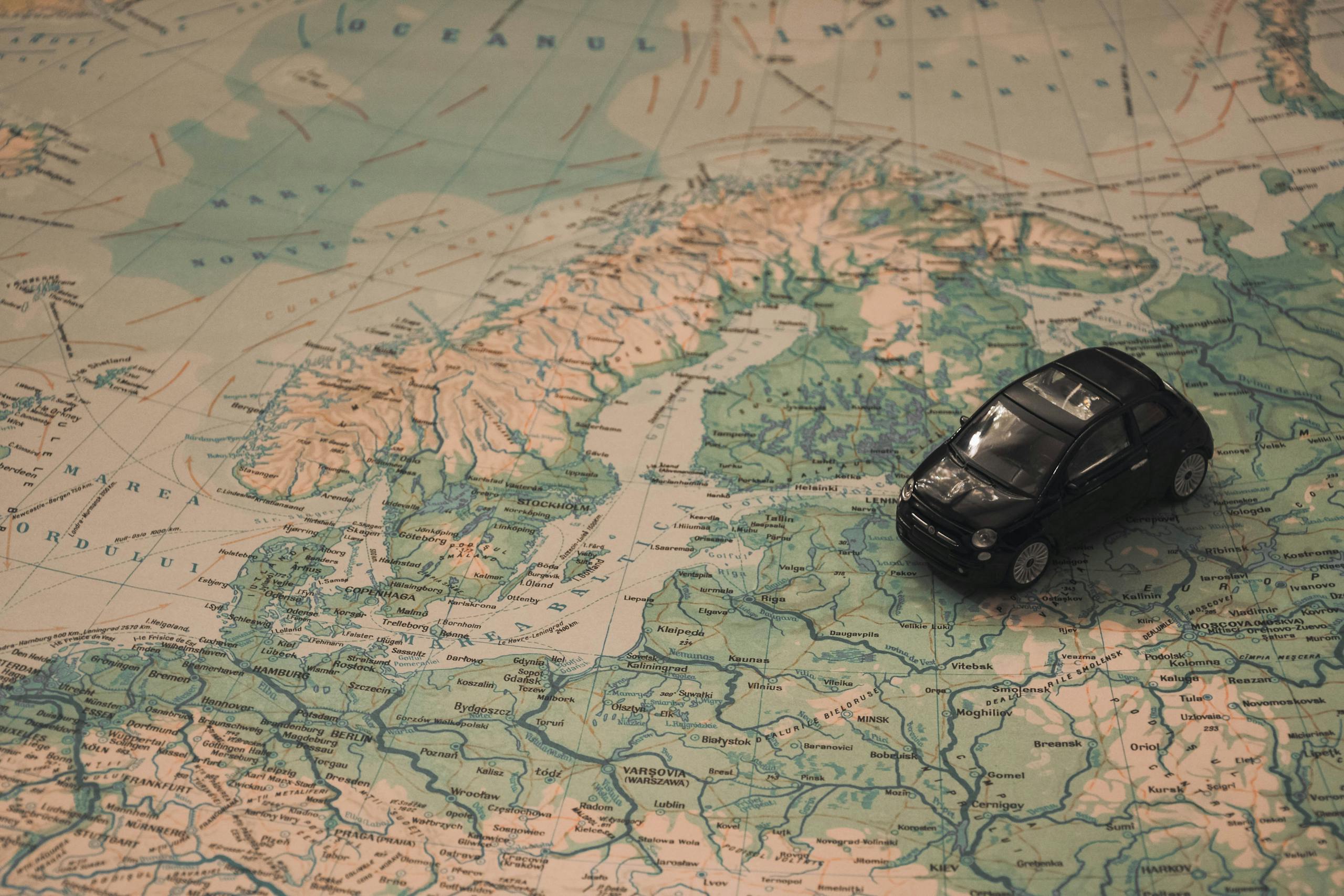 Black Toy Car on World Map Paper