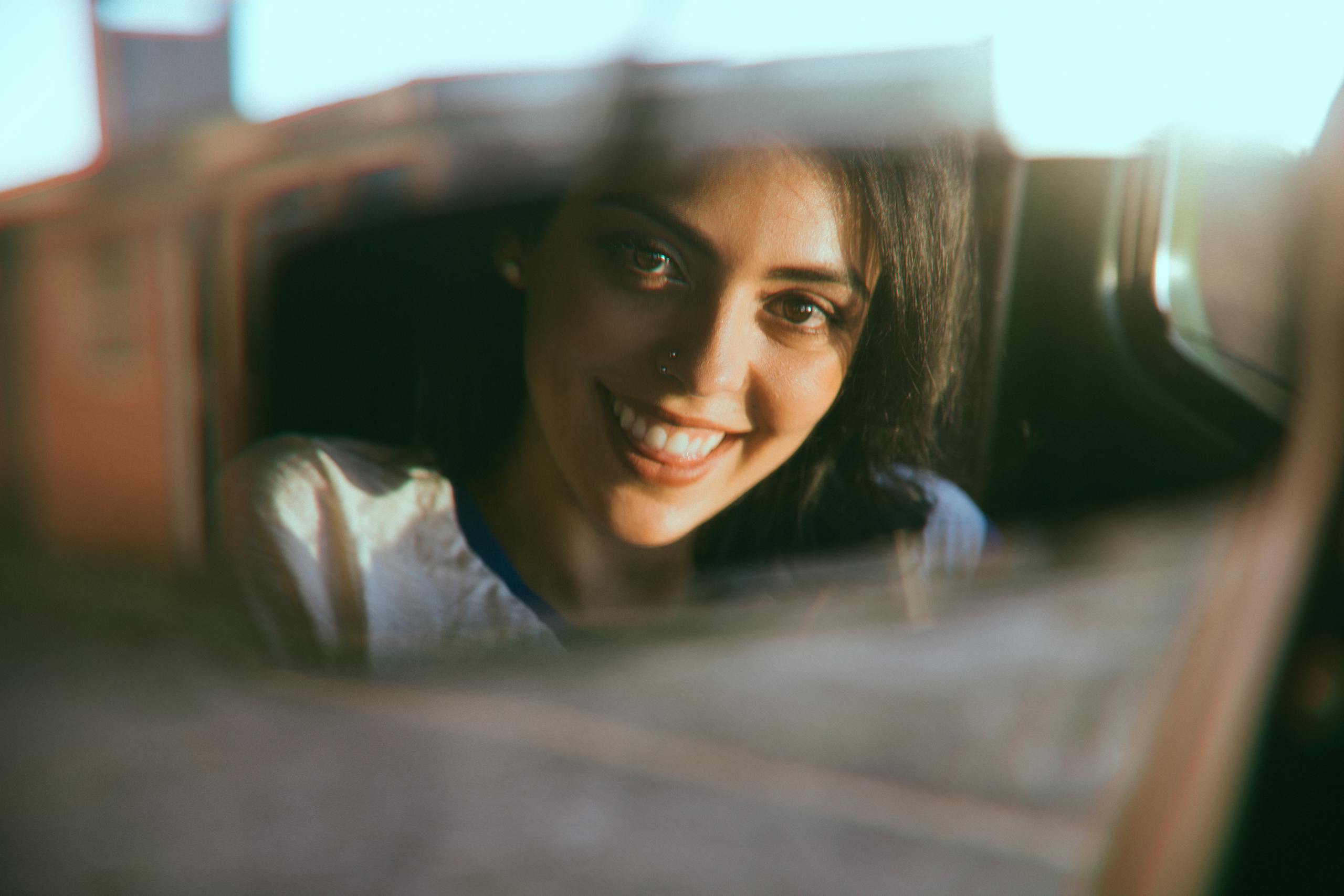 Reflection of cheerful woman in car window